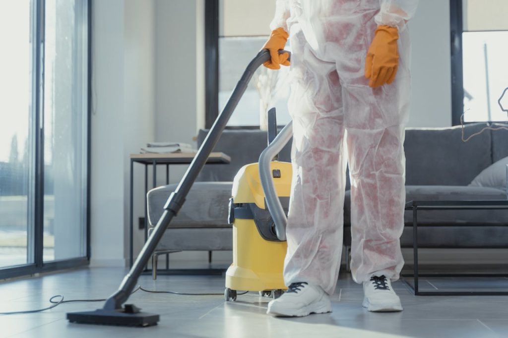 The Art of Drawing Readers In: Your attractive post title goes here A cleaner in protective coveralls and gloves vacuuming a modern living room.